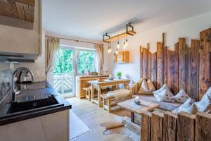kuchnia i salon z kanapą i stołem w obiekcie Landhaus Theresia w mieście Maria Alm am Steinernen Meer