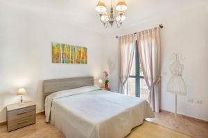 a bedroom with a bed and a dresser and a window at Mannois - Lofts & Apartments in Orosei