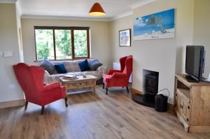 salon z kanapą, 2 krzesłami i telewizorem w obiekcie Island View Townhouses w mieście Clifden