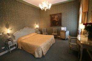 a bedroom with a bed and a chandelier at Locanda Ca' del Brocchi in Venice