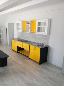 a kitchen with yellow cabinets and a sink at Cityap Apartments in Martinske Hole