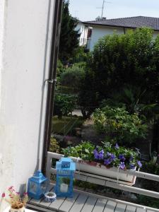 un balcone con panchina piena di fiori e piante di Ichnussa a Udine