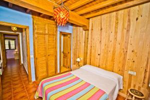 Un dormitorio con una cama en una habitación con paredes de madera. en Casa del Herrero, en Mogarraz