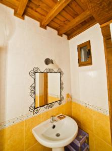 un baño con lavabo y espejo en Casa del Herrero, en Mogarraz