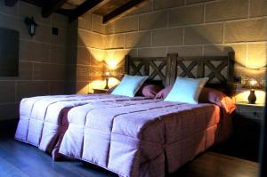 a bedroom with a large bed with two pillows at Casa Rural Estrela in San Martín de Trevejo