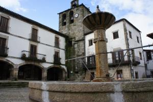 an old building with a clock tower in front of it at Casa Rural Estrela in San Martín de Trevejo +7 photos
