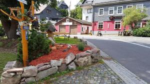 a street with a stone wall next to a road at Pension & Gasthof "Am Park" UG in Stützerbach +48 photos