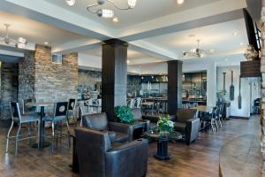un restaurante con sillas, mesas y una pared de ladrillo en Oxford Suites Silverdale en Silverdale