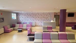 una sala de espera con sillas de color púrpura y blanco en Hotel Troncoso, en Sanxenxo