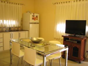 cocina con mesa, TV, mesa y sillas en Don Gregorio, en Merlo