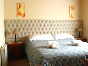 a bedroom with a bed with two stuffed animals on it at Don Gregorio in Merlo