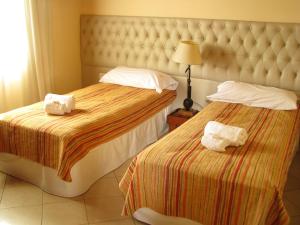 a hotel room with two beds with towels on them at Don Gregorio in Merlo
