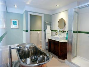a bathroom with a tub and a sink at Embankment Hotel in Bedford