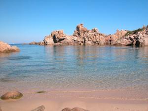 una spiaggia con alcune rocce in acqua di Villino Li Sambuli a Costa Paradiso