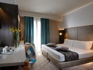 a hotel room with a bed and a desk in it at Elite Hotel & Spa in Mestre