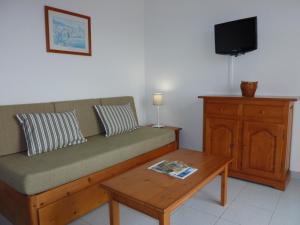 a living room with a couch and a coffee table at Apartamentos Villa Primera in Cala Figuera