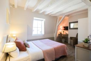 a bedroom with a bed and a desk and a window at Hôtel L'Adresse in Tours