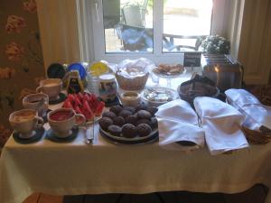 een tafel met voedsel en bekers en borden met voedsel bij Tulbi Guesthouse in Pärnu