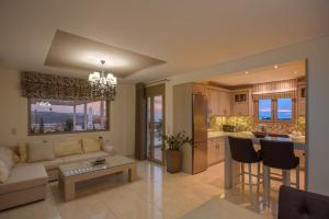 a living room with a couch and a kitchen at Golden Sky Villa in Kamilari