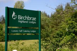 オニックにあるBirchbrae Highland Lodgesのバーミンガム高原の山小屋の緑の看板