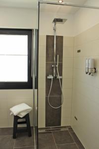 La salle de bains est pourvue d'une douche avec une porte en verre. dans l'établissement Ferienhaus am Rarbach, à Schmallenberg