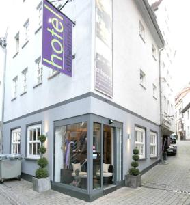 ein Laden mit einem lila Schild an der Seite eines Gebäudes in der Unterkunft Hotel Ottheinrich in Weinheim