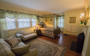 - un salon avec un lit et un canapé dans l'établissement Thornhedge Inn, à Bar Harbor