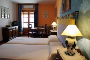 a bedroom with two beds and a lamp on a table at Hotel De Mecina Fondales in Mecina Fondales