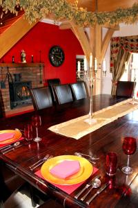 a dining room with a wooden table with red walls at Backbrae House Luxury B&B in Lanark