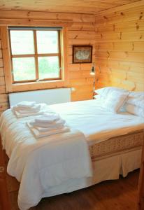 a bedroom with a large white bed with a window at Geysir - Modern Log Cabin in Reykholt