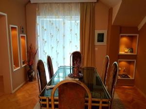 uma sala de jantar com uma mesa de vidro e cadeiras em Apartment Cace em Kumanovo