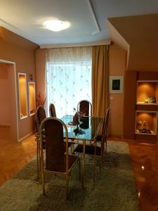 a dining room with a glass table and chairs at Apartment Cace in Kumanovo