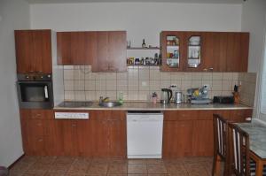 eine Küche mit Holzschränken und einem weißen Geschirrspüler in der Unterkunft Guesthouse Djurić in Negotin + 51 Fotos