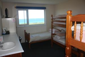 a bedroom with a bunk bed and a sink and a window at Longbeach- Adults Only in Newquay