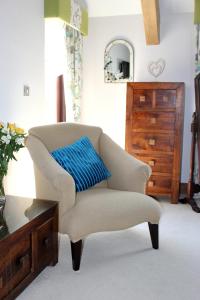 a chair with a blue pillow in a living room at Backbrae House Luxury B&B in Lanark