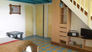 a bedroom with a bed and a staircase with a television at Habitation Pineau in Deshaies