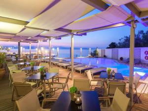 restauracja ze stołami i krzesłami oraz basen w obiekcie Cabo Verde Hotel w mieście Mati