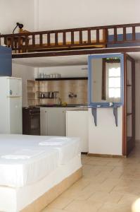 a kitchen with a bed in a room with a kitchen at La Mirage in Nea Fokea