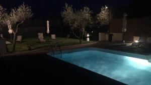 uma grande piscina à noite com luzes em Maine case vacanza em Cortona