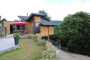 een houten huis met een veranda en een patio bij Gite Le chataignier in Luttenbach-près-Munster
