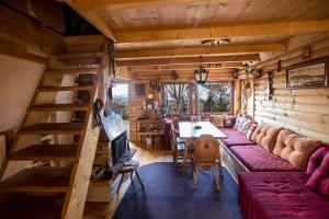 a living room with a long couch and a table at Chalet Baluma Maluba in Jahorina