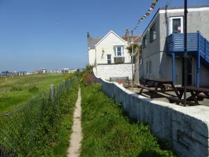 a dirt road next to a fence next to a house at Longbeach- Adults Only in Newquay