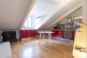 トリノにあるFrancesco da Paola 10の赤いキャビネットとテーブル付きのキッチンが備わります。