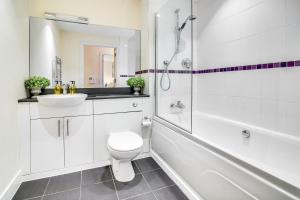 a bathroom with a toilet and a sink and a shower at The Class Place in Birmingham +23 photos