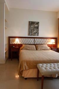 Alta Piazza –Casa di Appartamenti– في بوينس آيرس: غرفة نوم بسرير كبير وموقف ليلتين