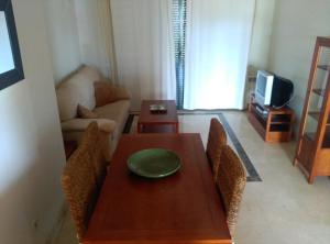 sala de estar con mesa y sofá en Casa Rosie, en Los Alcázares