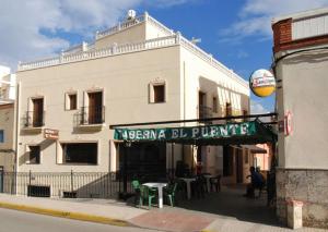 un edificio con un letrero al lado de una calle en Hostal el Puente, en Tabernas