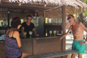 a group of people standing around a bar with drinks at Cabanas Las Estrellas in Palomino