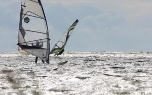 two people are windsurfing in the ocean at Treimani Country House in Treimani