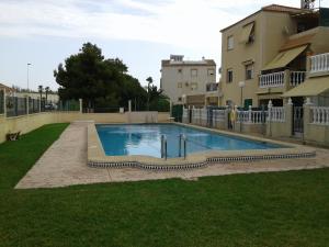a swimming pool in a yard next to a building at Apartement à La Mata in Torrevieja